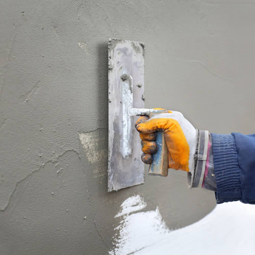 A stucco contractor plastering a wall